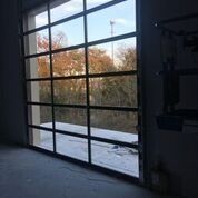 A garage door with a lot of windows and a view of a snowy yard.