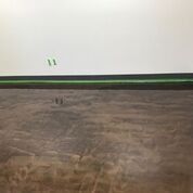 A room with a wooden floor and a white wall.