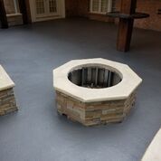 A fire pit is sitting on top of a concrete patio.