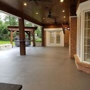 A large covered porch with a ceiling fan and a pergola.