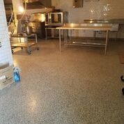 A kitchen with a stainless steel table and a stainless steel oven.