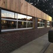A brick building with a wooden roof and lots of windows.
