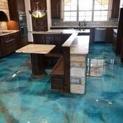 A kitchen with a blue epoxy floor and a table.