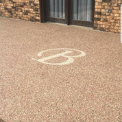 A patio with a handicap sign on it in front of a brick building.
