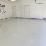 A large empty garage with a white floor and white walls.
