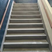 A close up of a set of stairs with a railing.