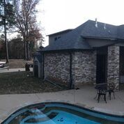A house with a swimming pool in front of it.