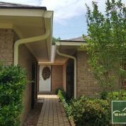 A brick house with a walkway leading to the front door.