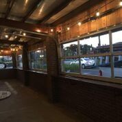 A room with a lot of windows and a car parked in the background.