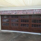 A garage door with a lot of windows and a brick wall.