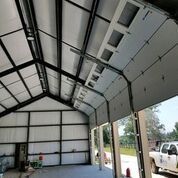 The inside of a garage with a truck parked in front of it.