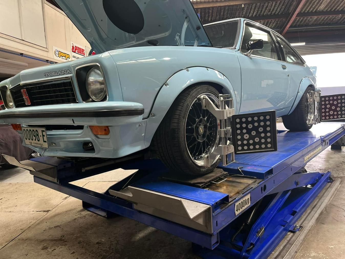 Torana Car On A Lift For A Special Wheel Alignment — Wheel Alignment in Wollongong, NSW