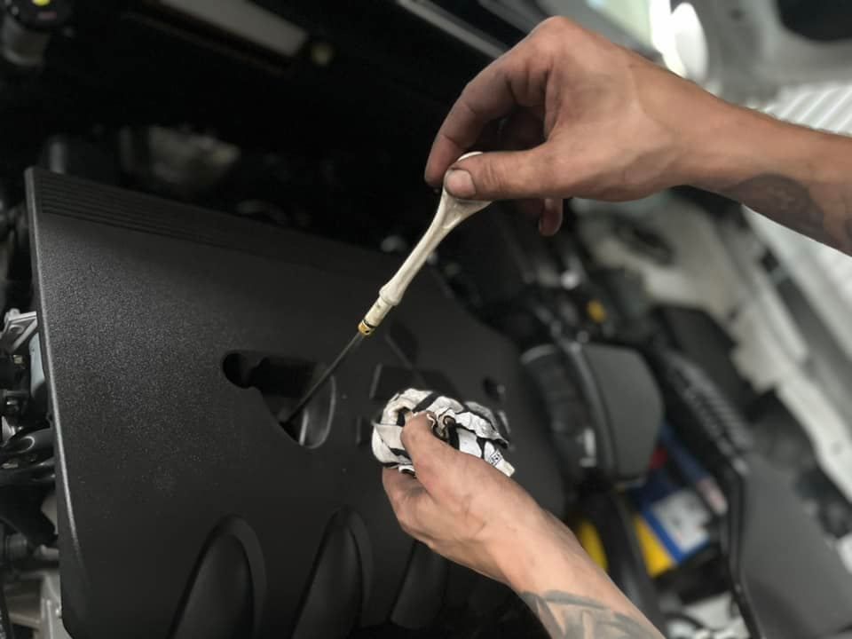 Man Checking The Car Engine Of A Red Car — Vehicle Inspections in Wollongong, NSW