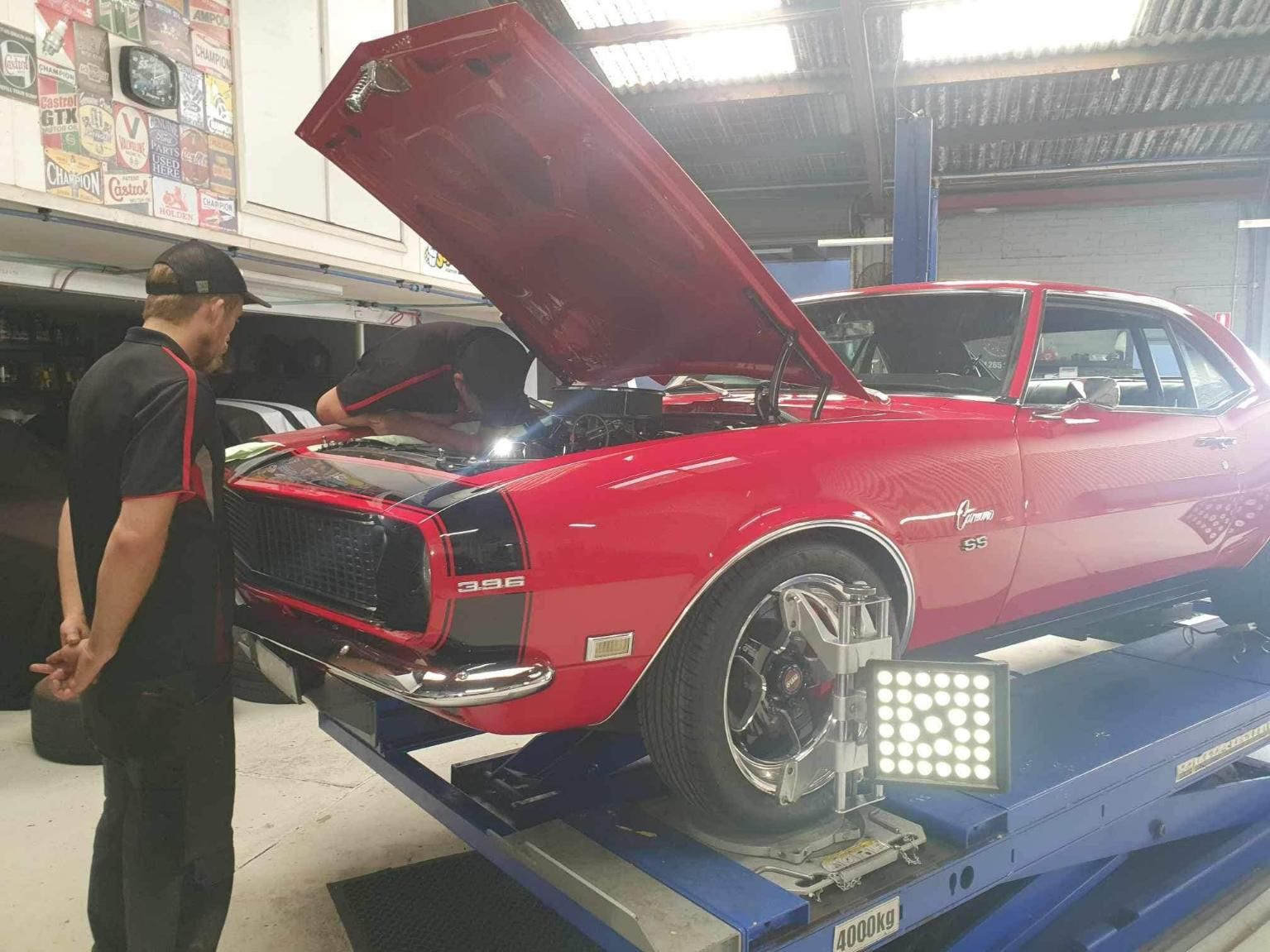 Two men are Working on a car in a Garage — Mechanic in Wollongong, NSW