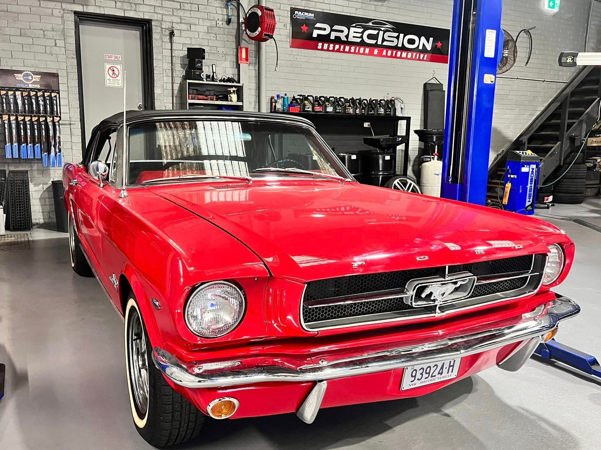A Red Mustang Convertible Is Parked in A Garage on A Lift — Mechanic in Wollongong, NSW