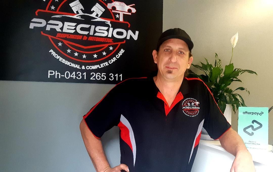A Red Car Is On A Lift In The Garage — Mechanic in Wollongong, NSW