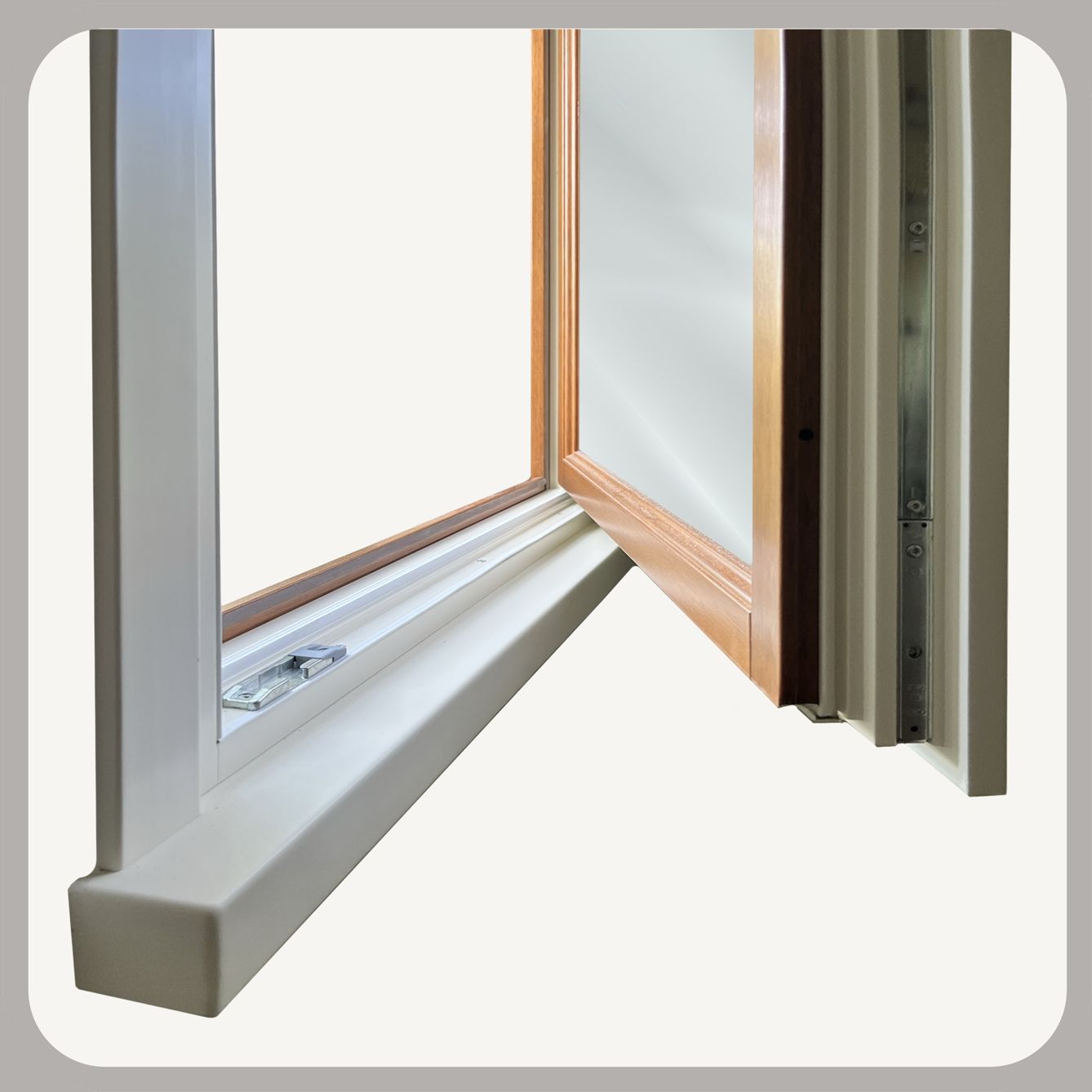 Primo piano di un telaio di finestra in legno marrone con chiusura in metallo e venature del legno ben visibili.