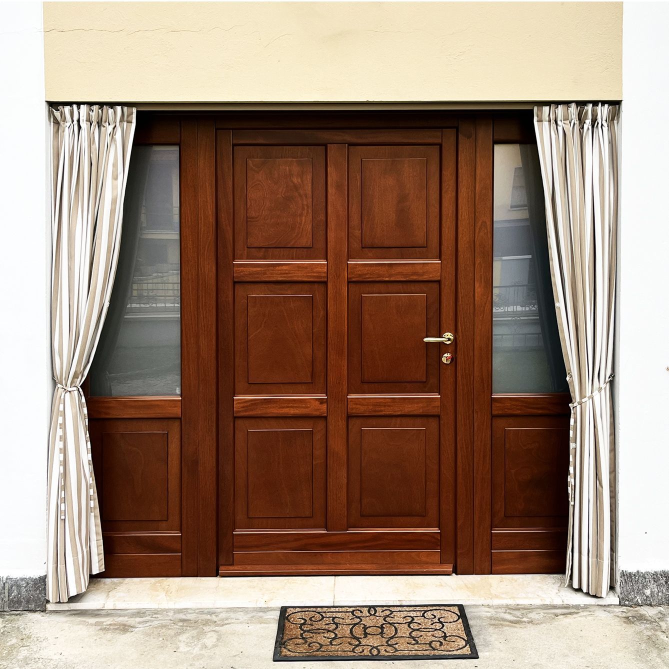 Una doppia porta in legno marrone con pannelli laterali satinati