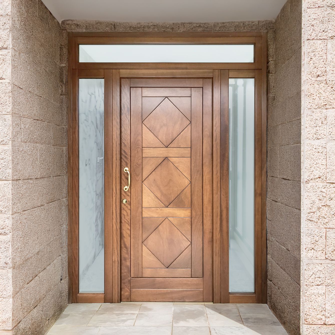Una porta d'ingresso in legno con tre pannelli a forma di diamante