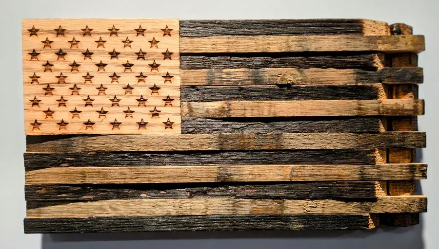 Wooden American flag art with charred stripes and star-filled wooden canton.