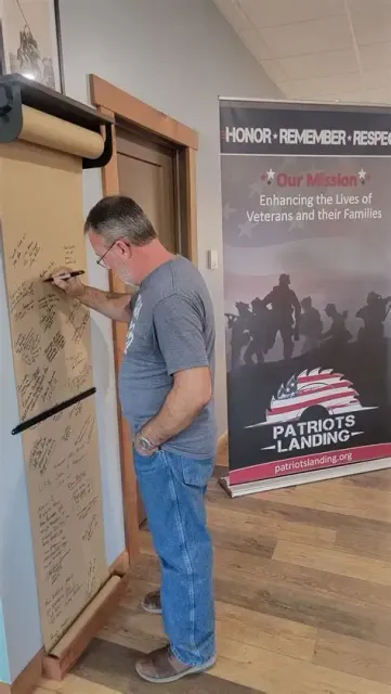 Man signing a paper roll at 
