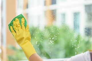 Home Cleaning — Hand with Yellow Gloves Cleaning in Neptune Beach, FL