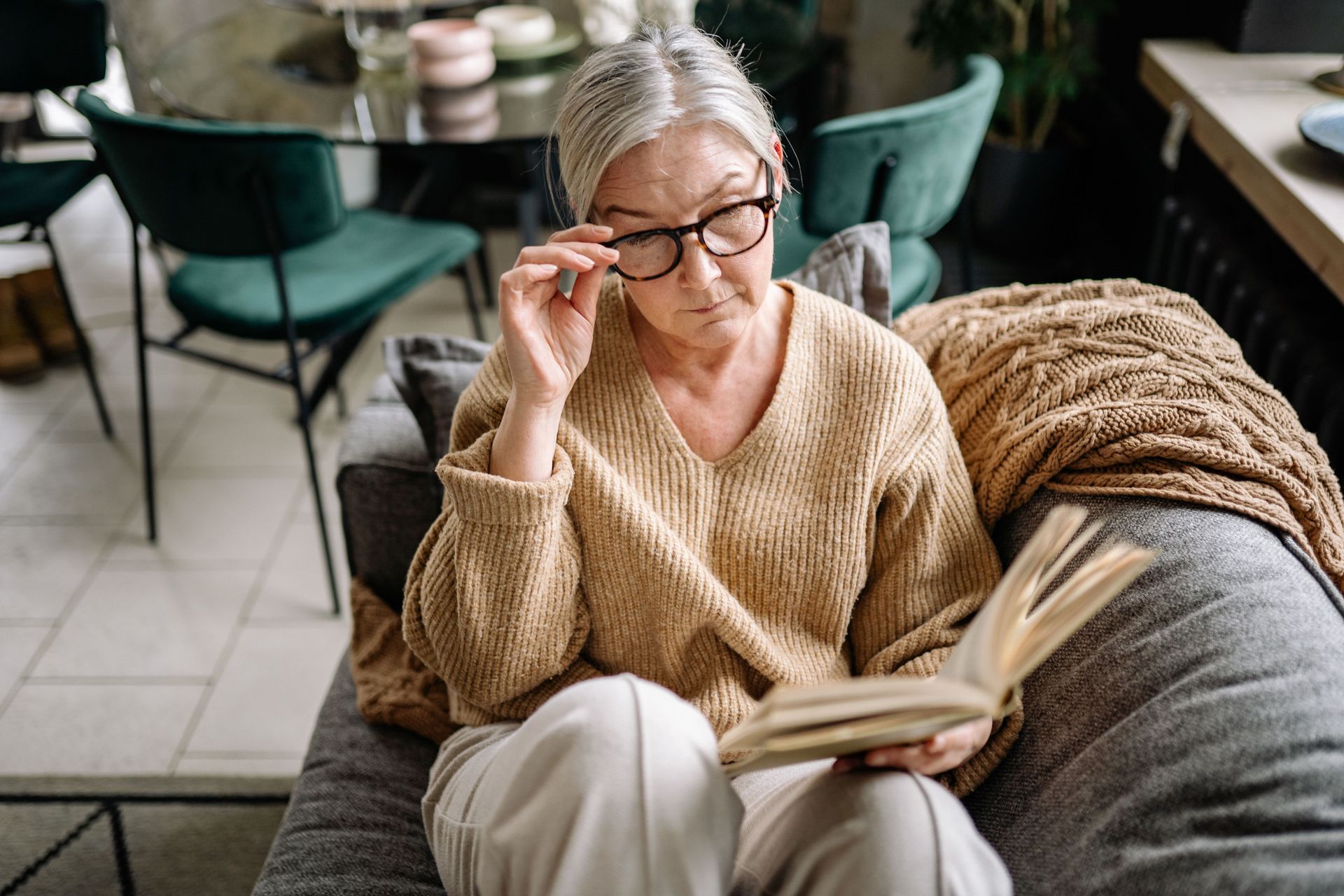 Person experiencing blurry vision while reading due to possible cataract symptoms