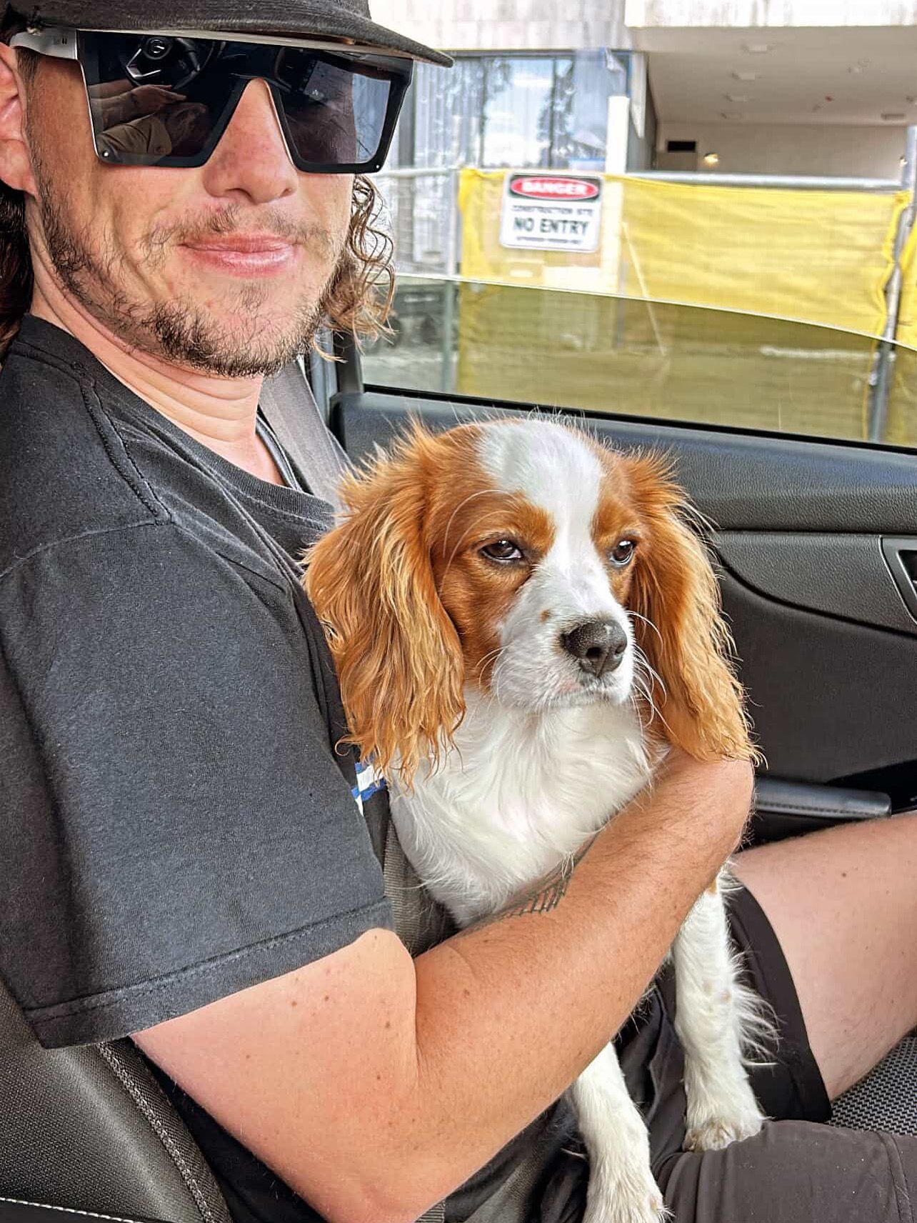 Man in camo hat holding a small puppy, both smiling — Mentally Hooked in Helensvale, QLD