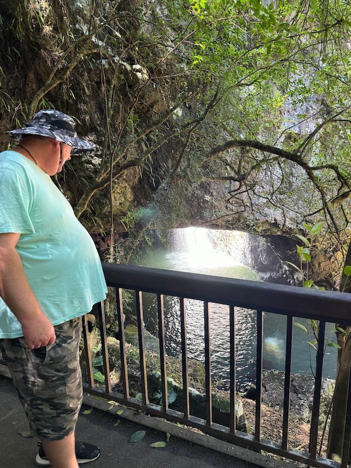 A Man is Standing on a Bridge Overlooking a Waterfall — Mentally Hooked in Robina, QLD