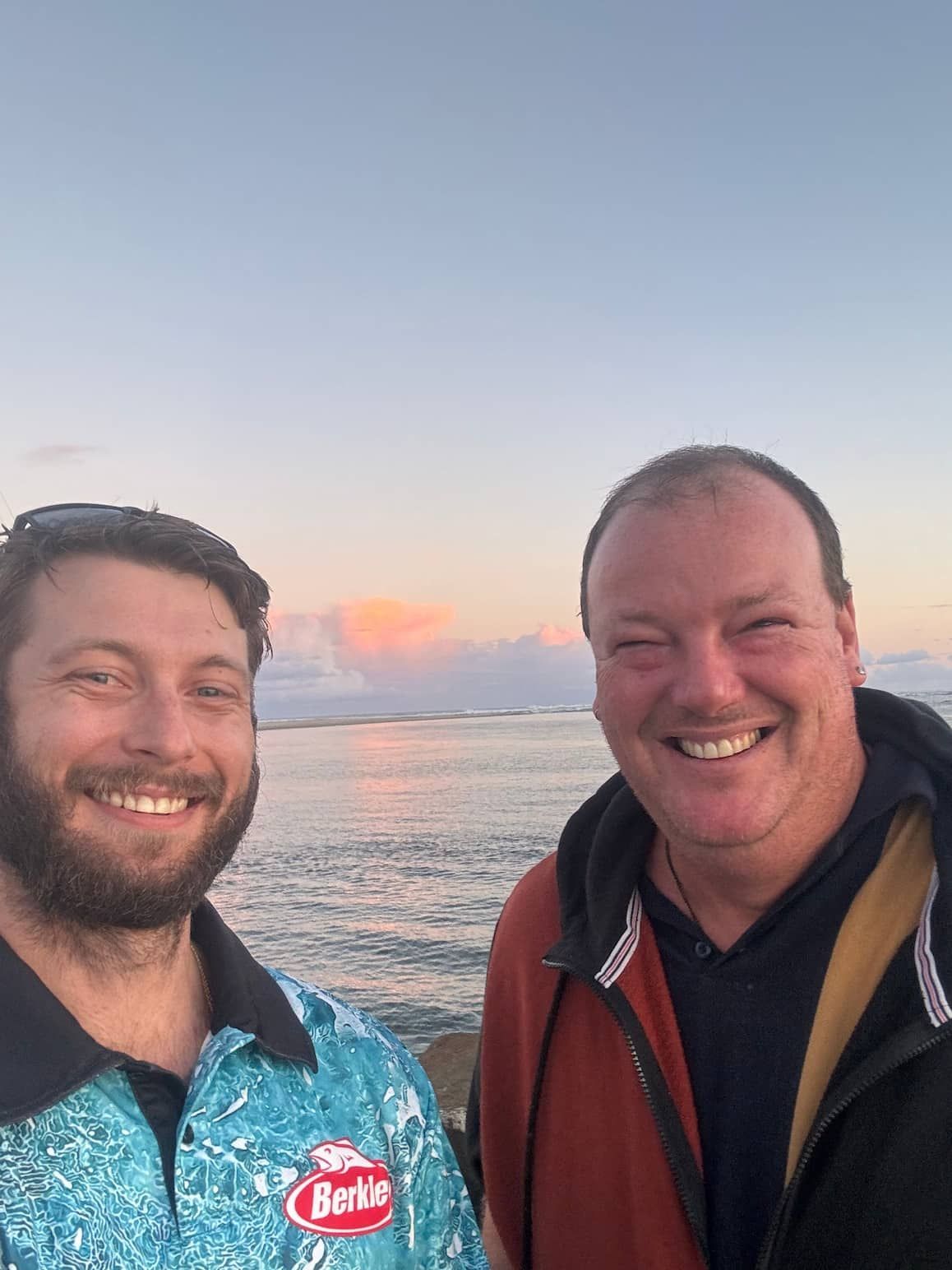 Two Men Are Posing for a Picture in Front of the Ocean — Mentally Hooked in Robina, QLD