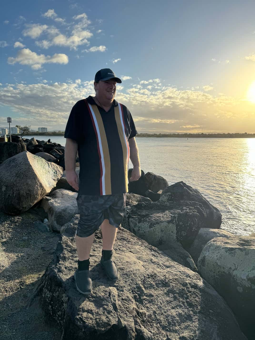 A Man is Standing on a Rock Near the Water — Mentally Hooked in Robina, QLD