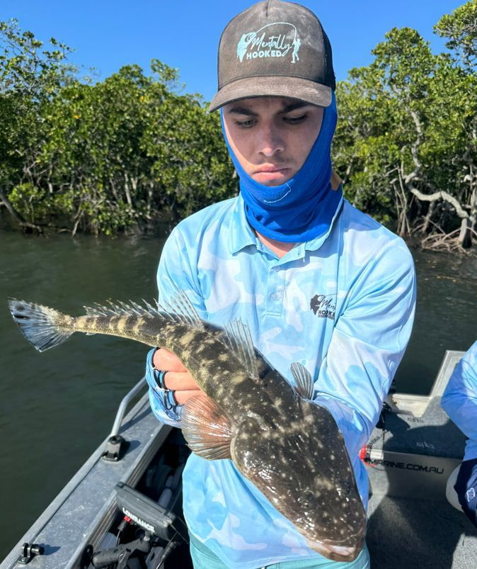 A Man is Holding a Large Fish on a Boat — Mentally Hooked in Robina, QLD