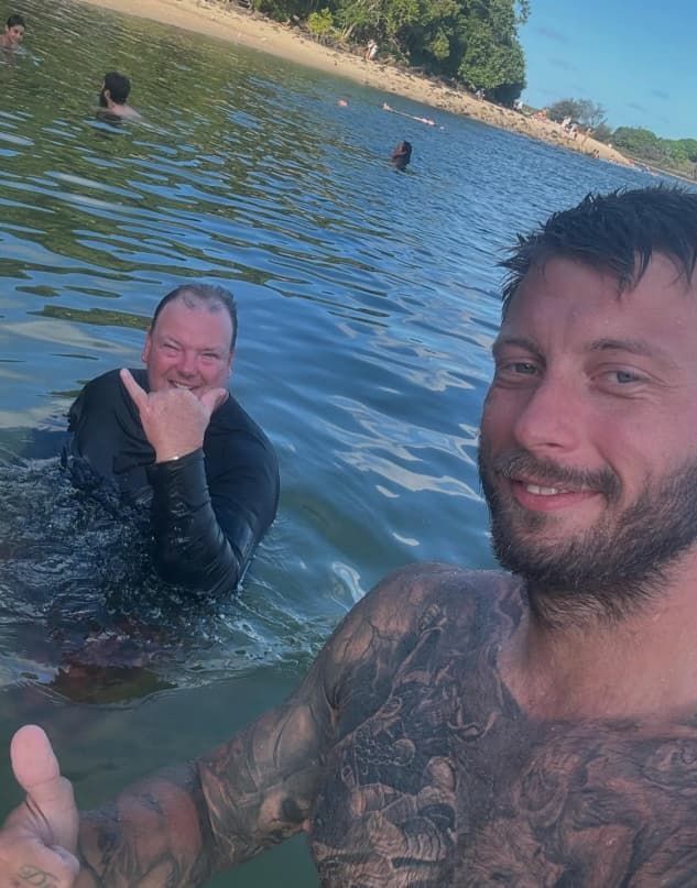 Two Men Are Swimming in a Lake and One of Them is Giving a Thumbs Up — Mentally Hooked in Robina, QLD