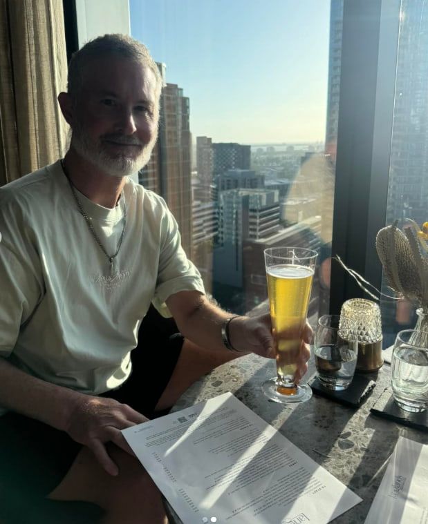 A Man is Sitting at a Table Holding a Glass of Beer — Mentally Hooked in Robina, QLD