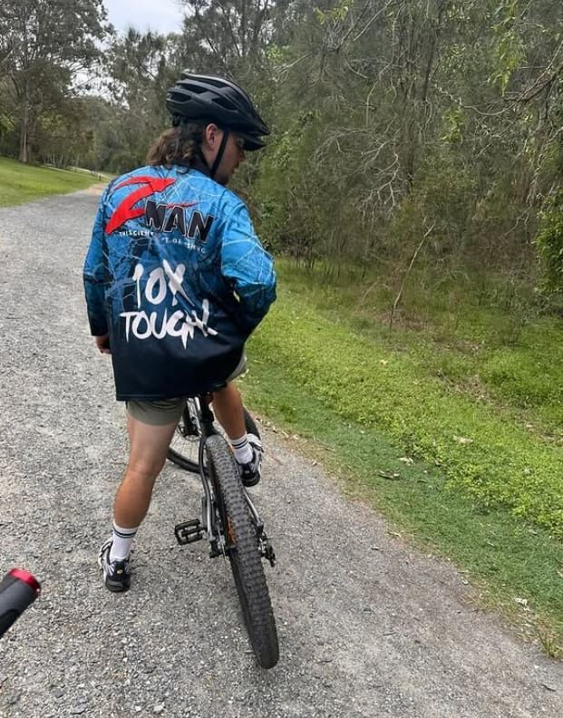 A Person is Riding a Bike Down a Dirt Road — Mentally Hooked in Robina, QLD