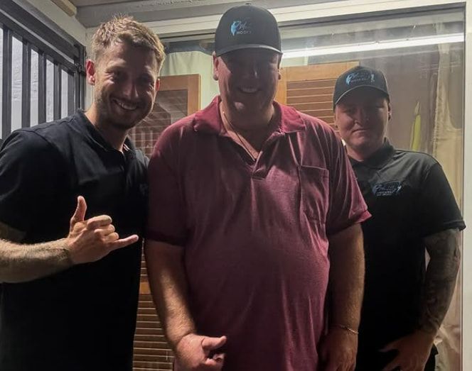 Three Men Are Posing for a Picture Together in a Room — Mentally Hooked in Helensvale, QLD