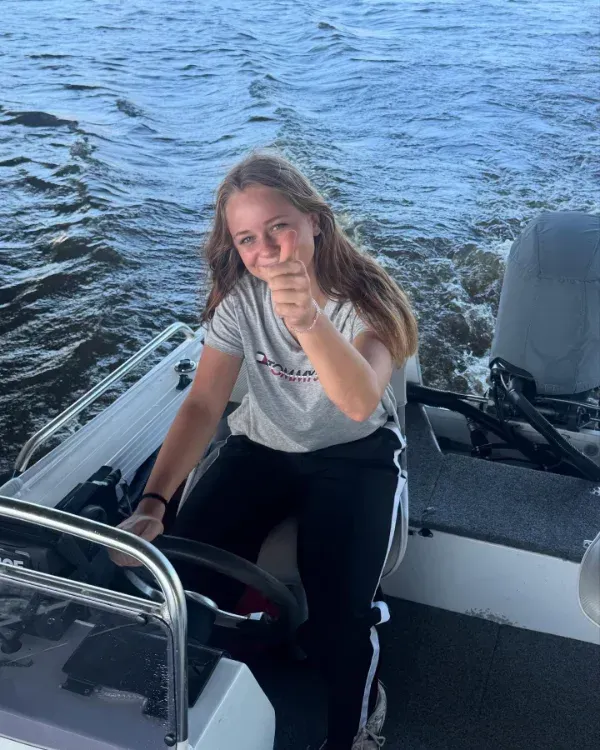 Young person piloting a boat, giving a thumbs-up — Mentally Hooked in Helensvale, QLD