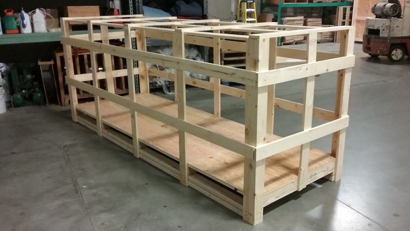 Wooden shipping crate. Light wood construction with open sides, in a warehouse setting.