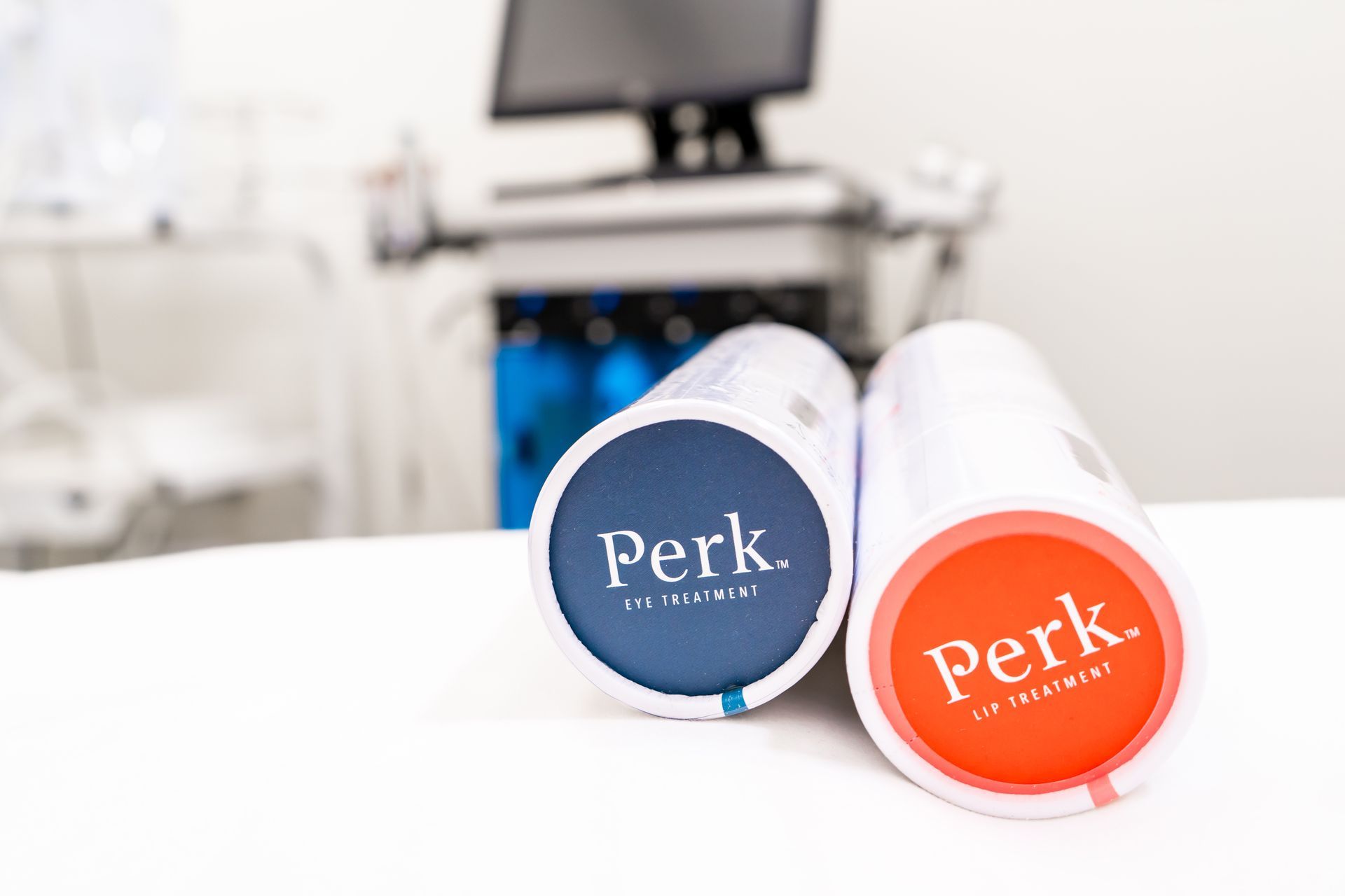 Two tubes with the word perk on them are sitting on a table.