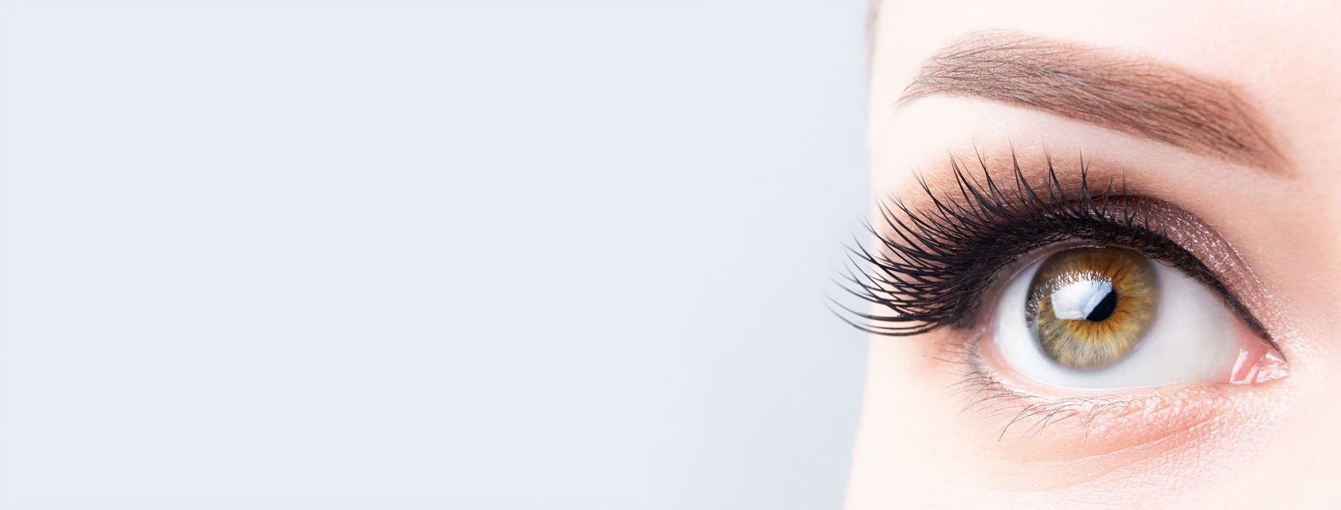 A close up of a woman 's eye with long eyelashes.