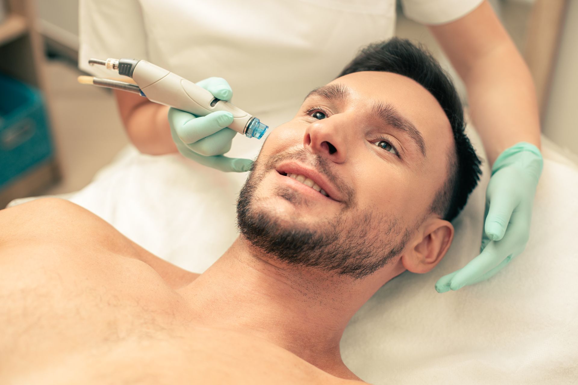 A man is getting a facial treatment at a beauty salon.