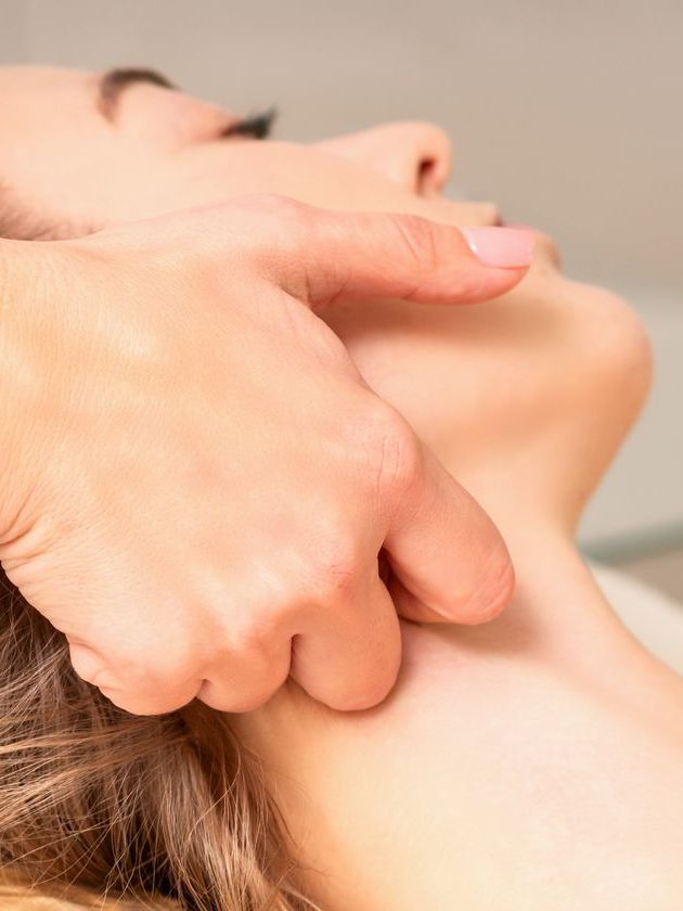 A woman is getting a massage on her neck.