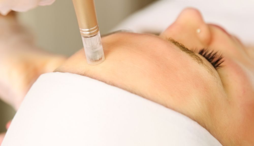 A woman is getting a facial treatment at a beauty salon.