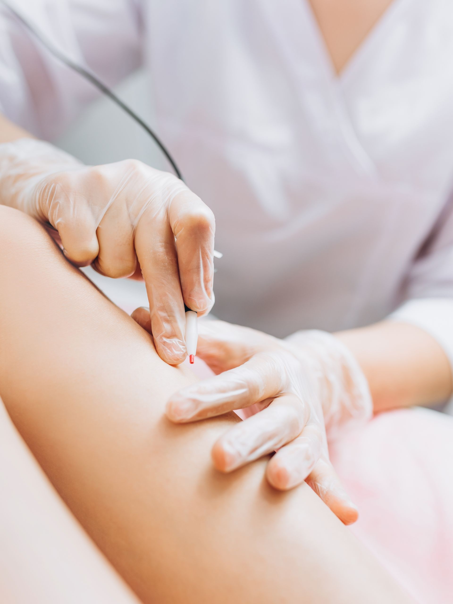 A woman is getting a laser treatment on her leg.