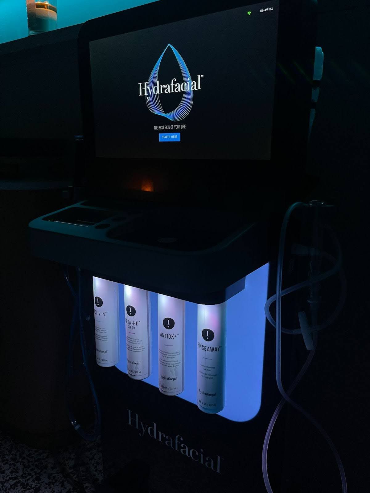 A hydrafacial machine is sitting in front of a computer monitor