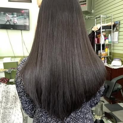 Woman with long, straight, black hair in a salon.