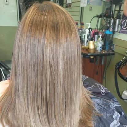 Woman with light brown, straight hair in a salon.