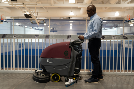 A person is using a machine to clean a granite floor.