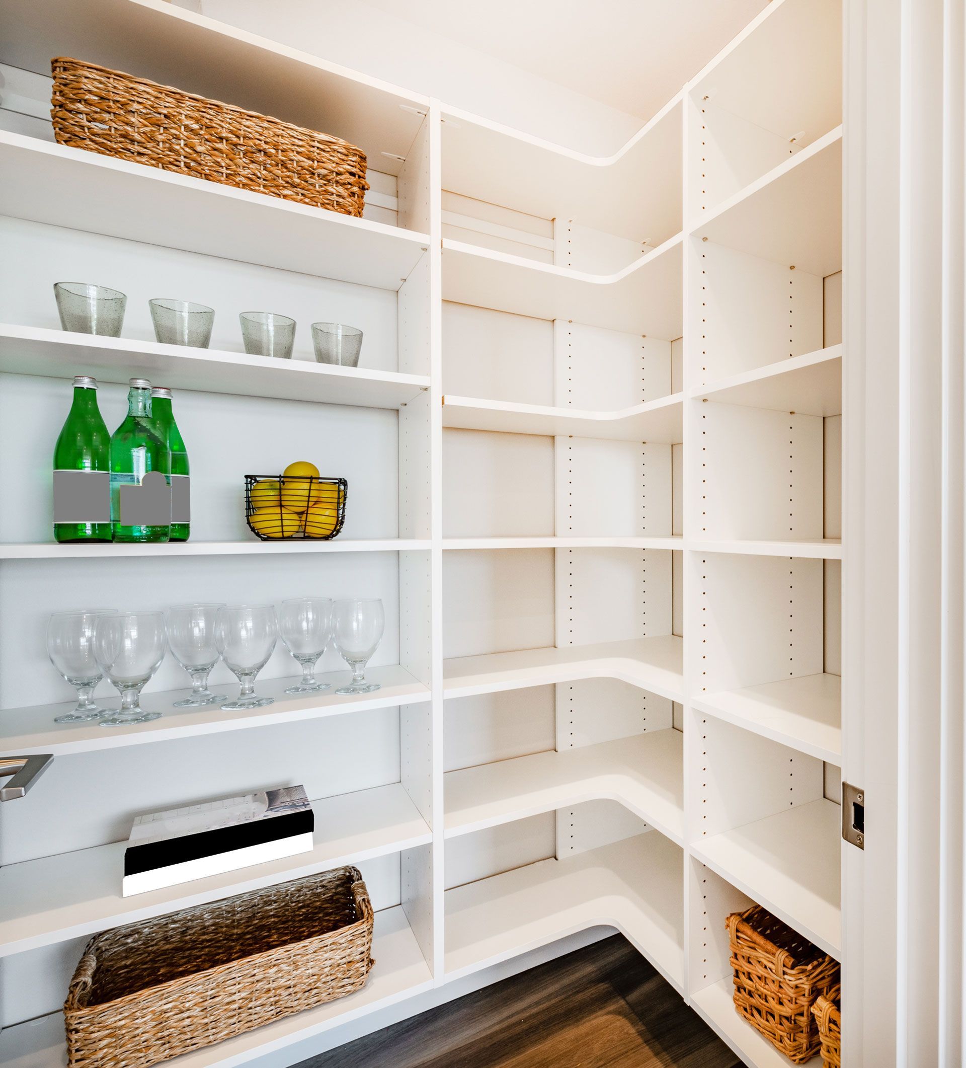 A pantry with lots of shelves filled with bottles and glasses.