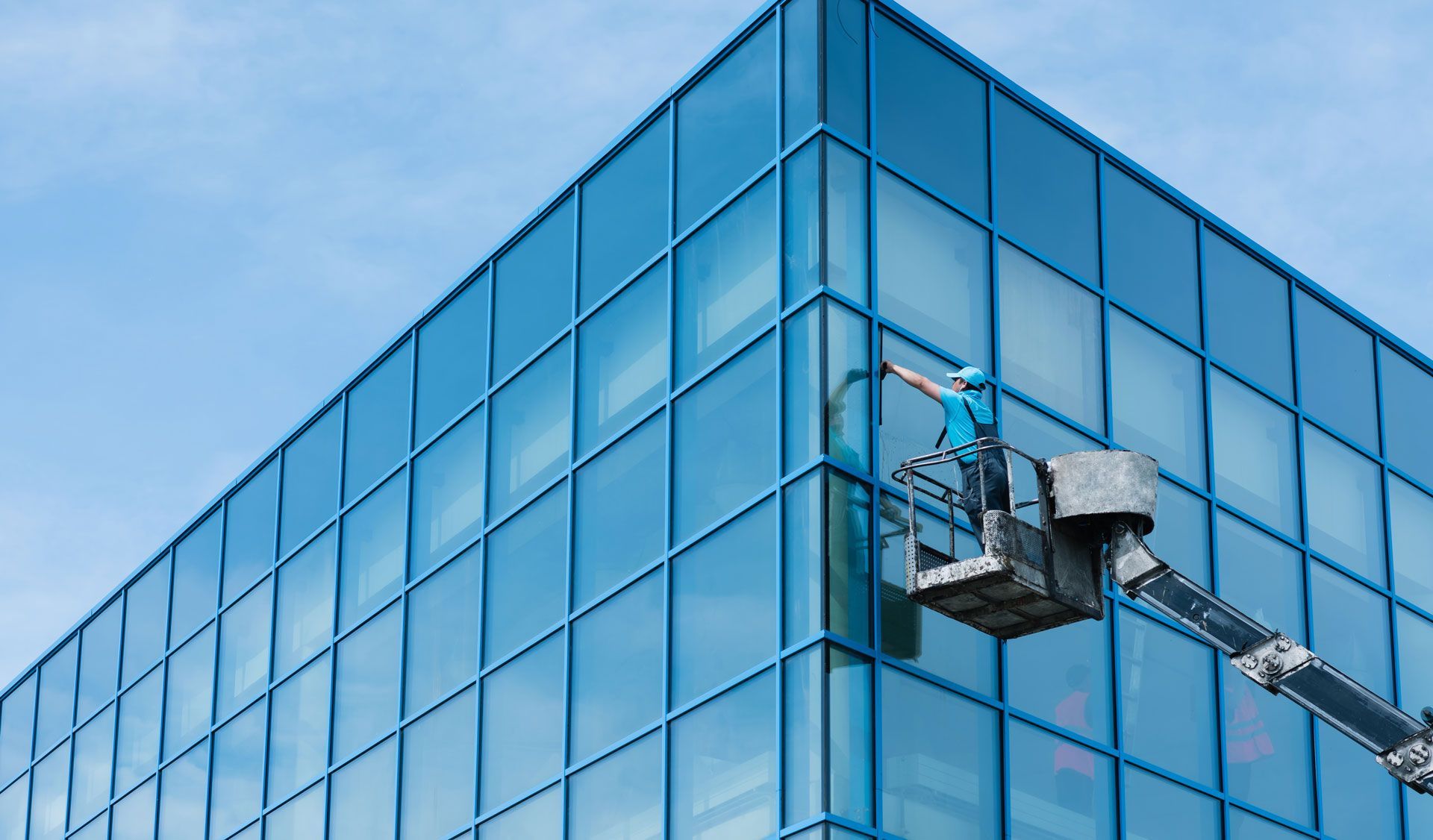 A man is cleaning the windows of a tall building.